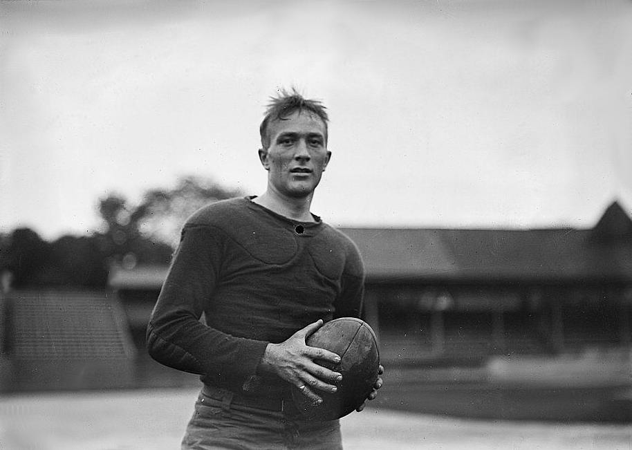 Black and white photo of a man holding a football