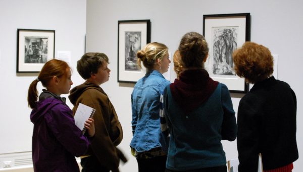 A group of people looks at art on a wall
