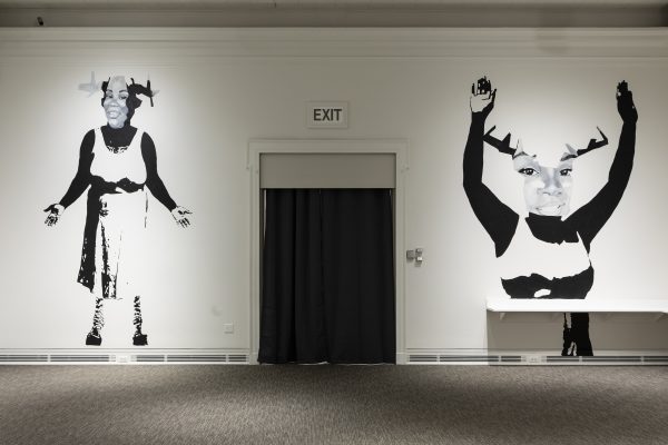 A grayscale painted mural of two images of Breonna Taylor with antlers