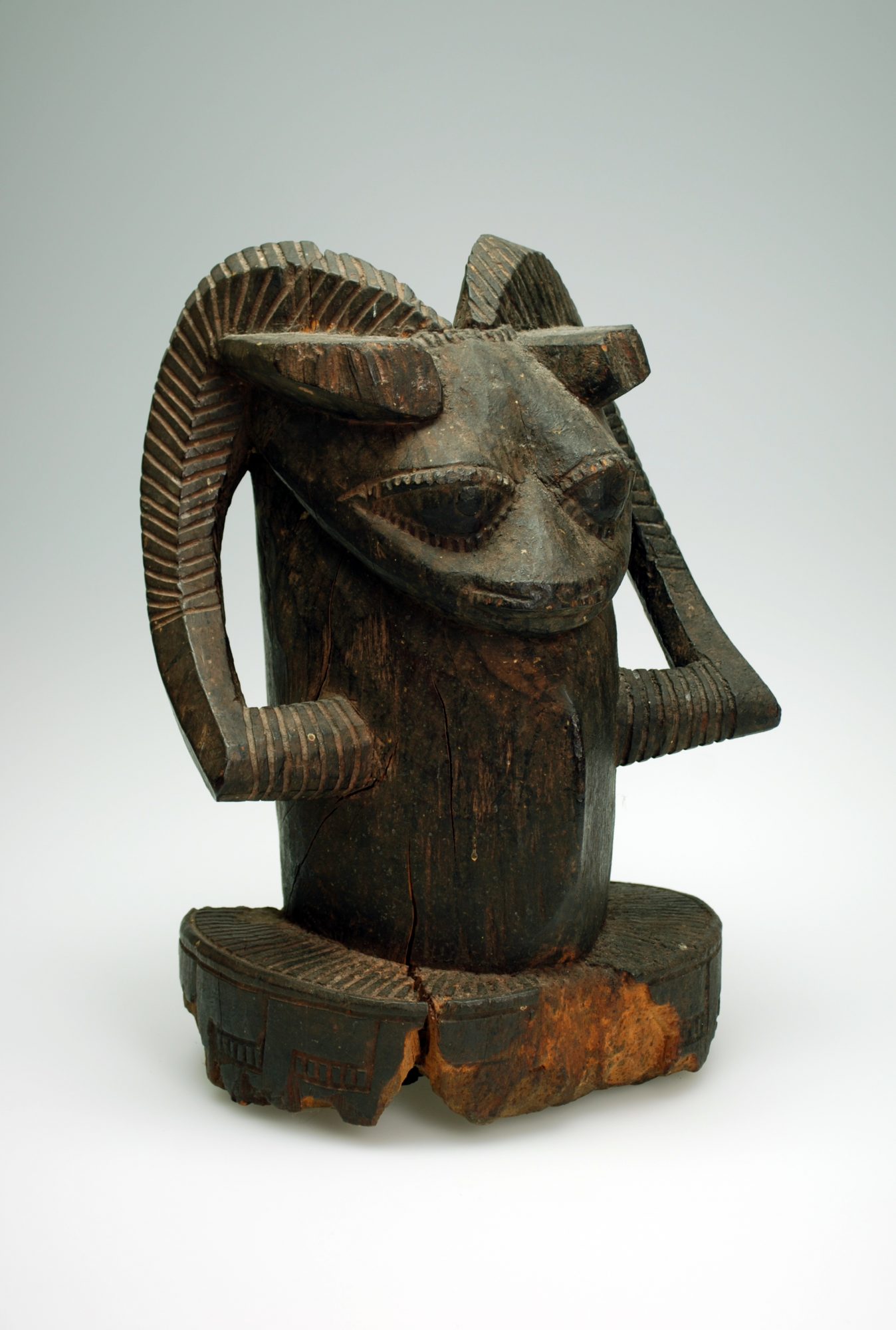 A ram's head sculpture carved from dark wood