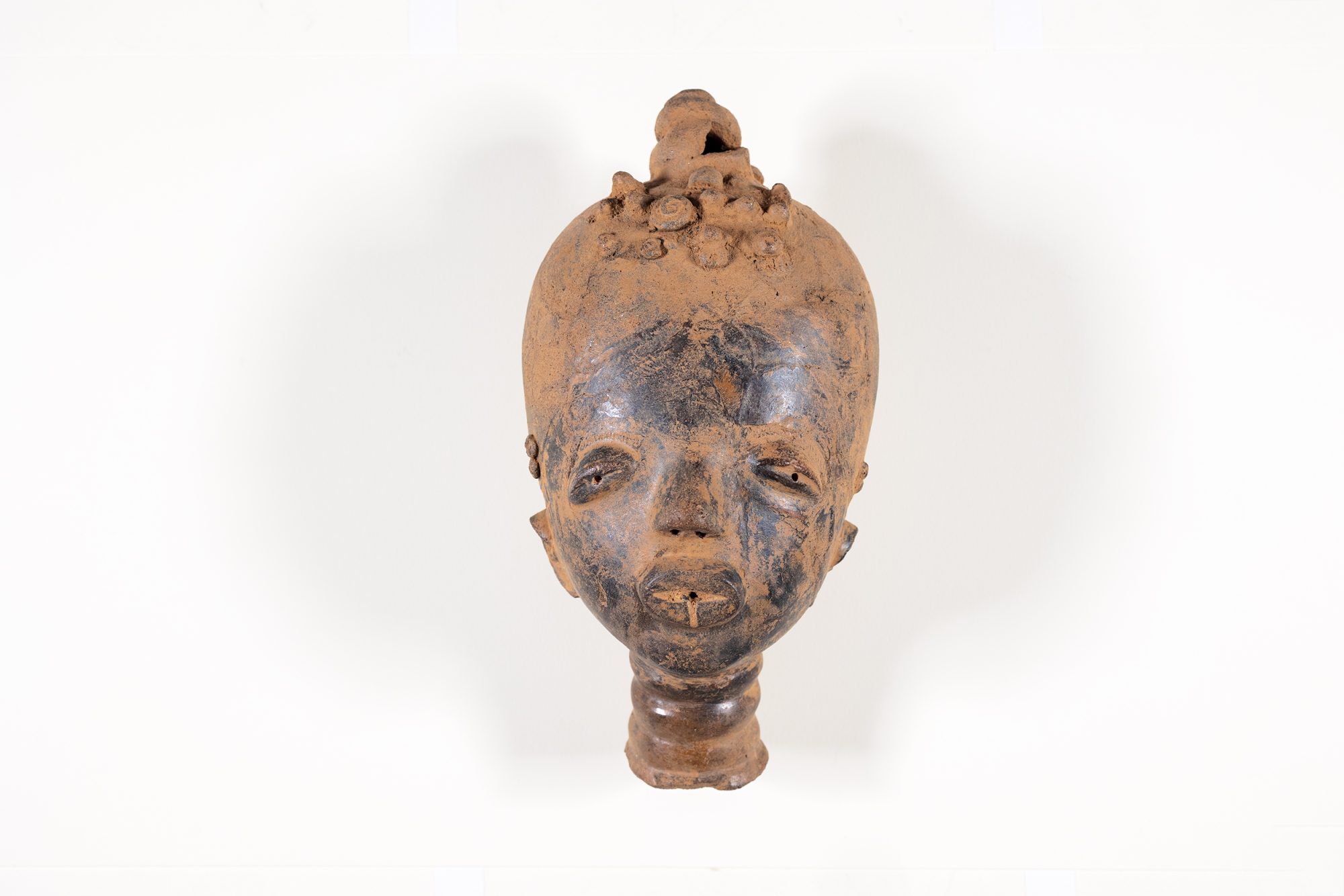 A sculpture of a head made of terracotta