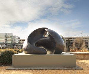 A sculpture made of two rounded bronze forms connected in the middle.