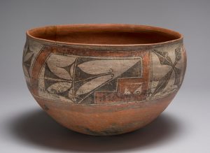 A red clay bowl decorated with drawing around the top border