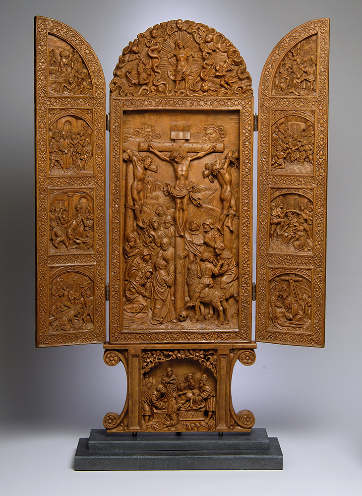 A three-part carved wooden altarpiece showing Christ's crucifixion