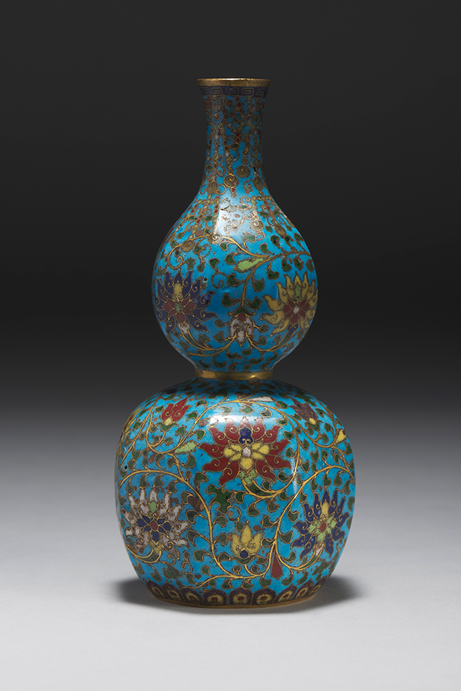 a blue vase, wide at the bottom and narrow in the middle and at the top, decorated with vines and flowers